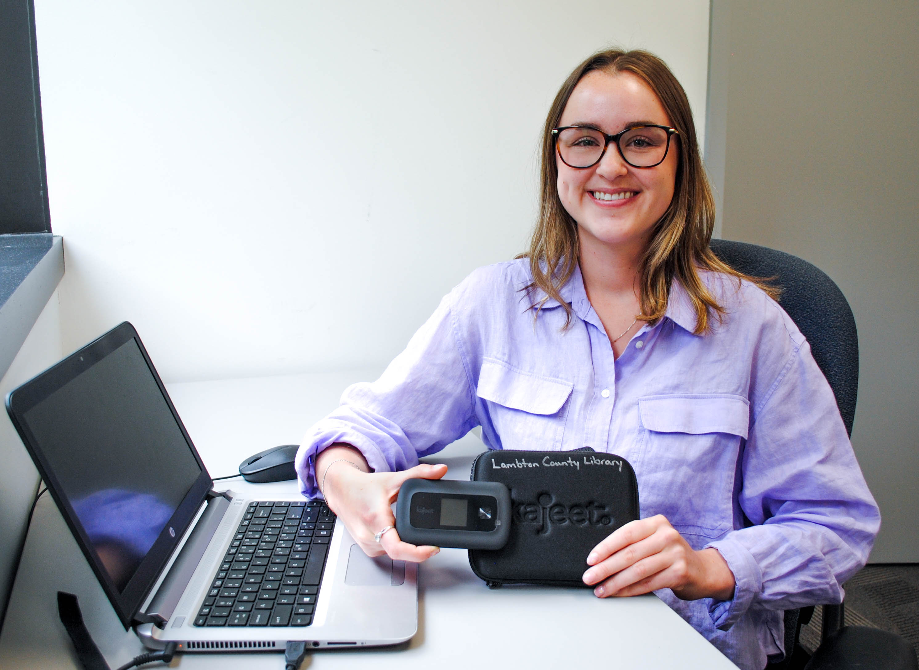 Ashlee Blackburn Online Resource Communications Student holds one of the Wi-Fi hotspots available to borrow from Lambton County Library