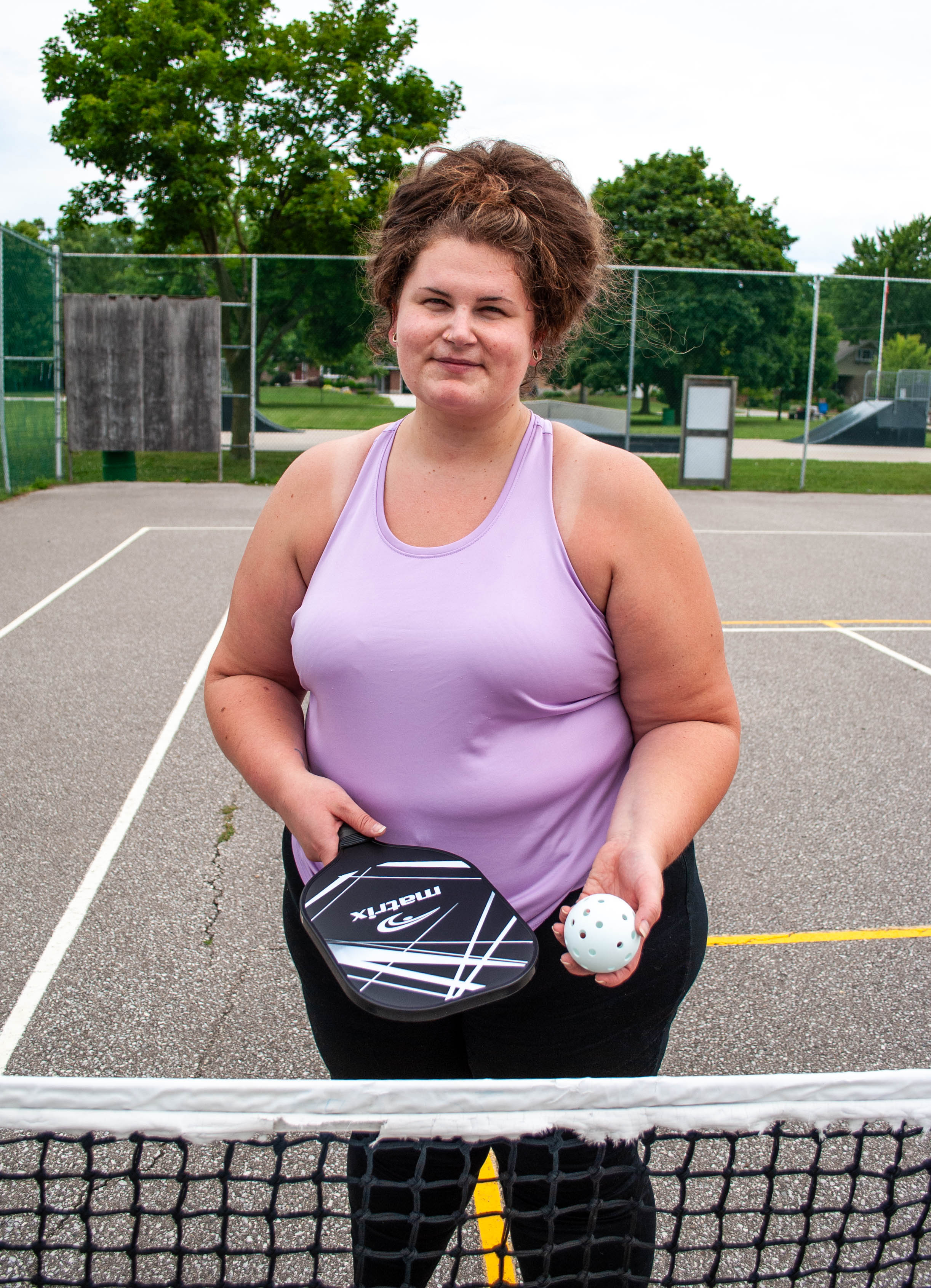 Nicole Cocker poses with the Pickleball Kit on a court